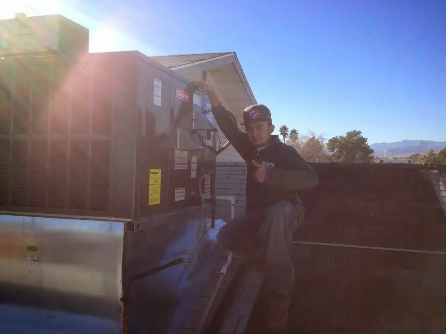 HVAC technician performing Air Duct Cleaning on a rooftop unit in Smyrna